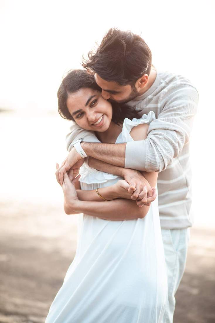 Couple in a close hug on the beach at golden hour