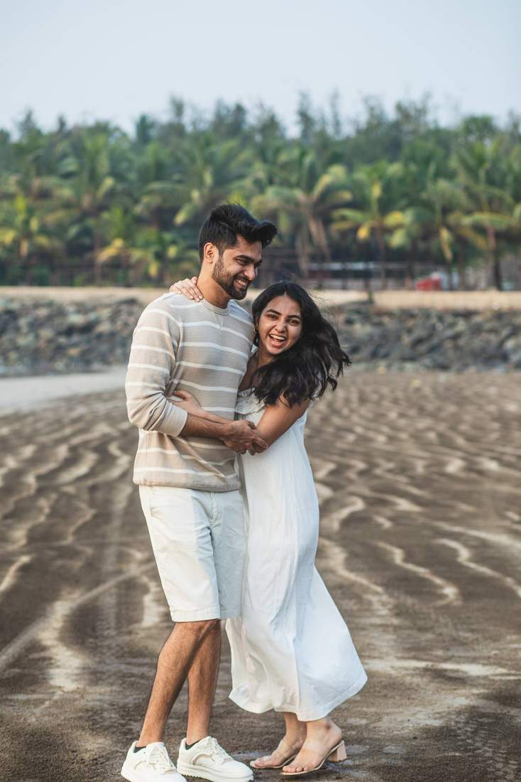 Couple hugging and laughing together on the sand