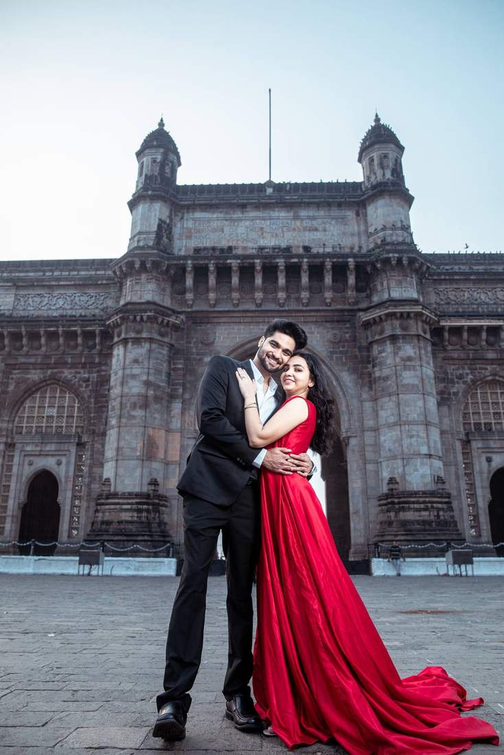 Bride in a flowing red gown, full length, before the Gateway of India