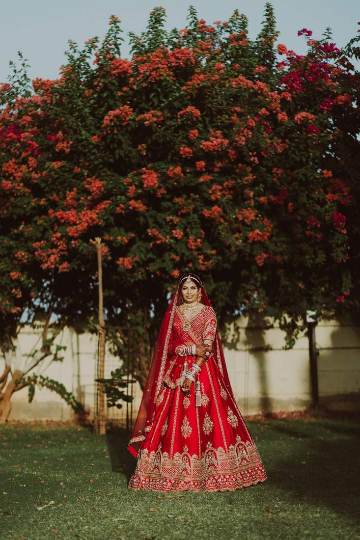 Bride standing before a blooming bougainvillea tree