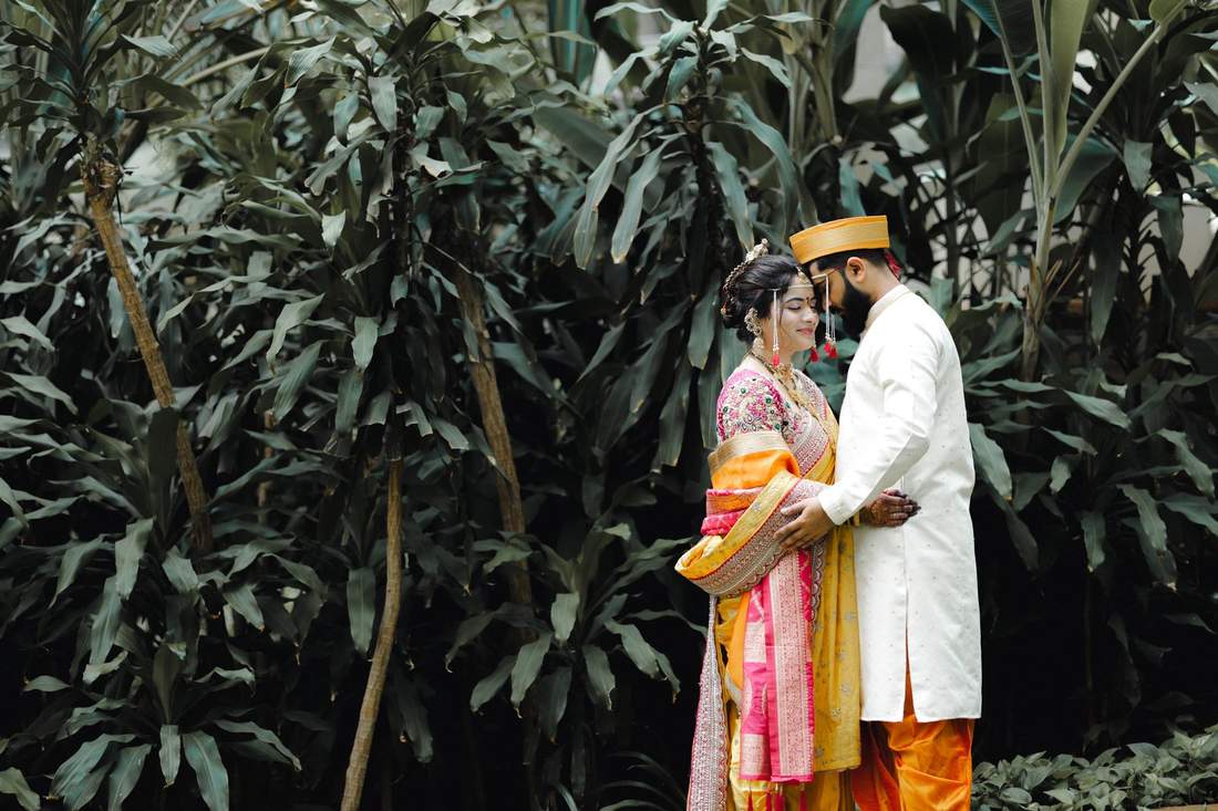 Couple in profile, foreheads touching, in a garden