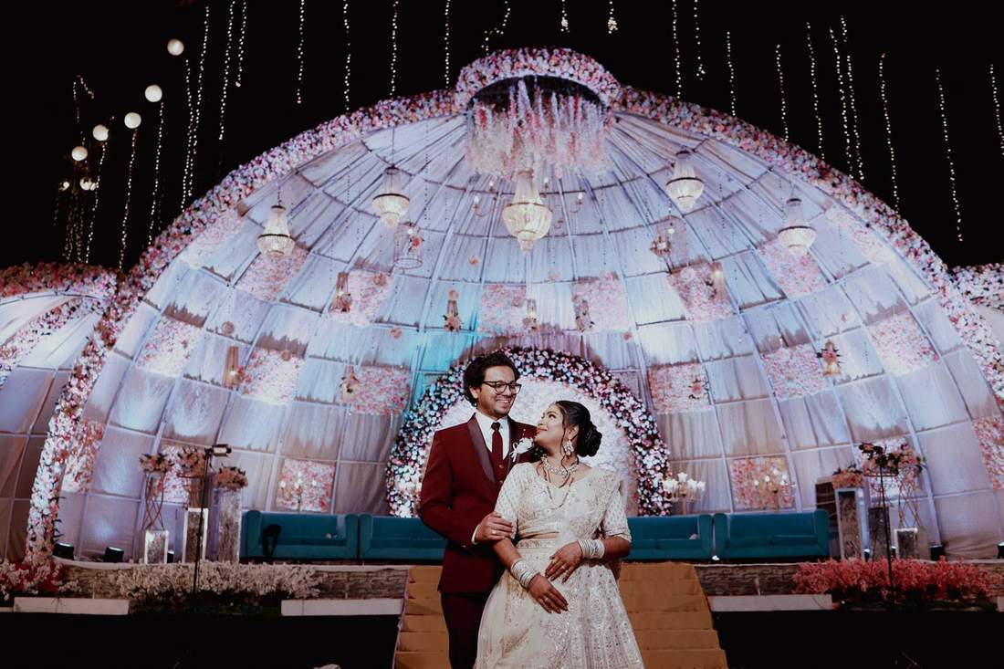 Couple standing before a glowing floral dome at night