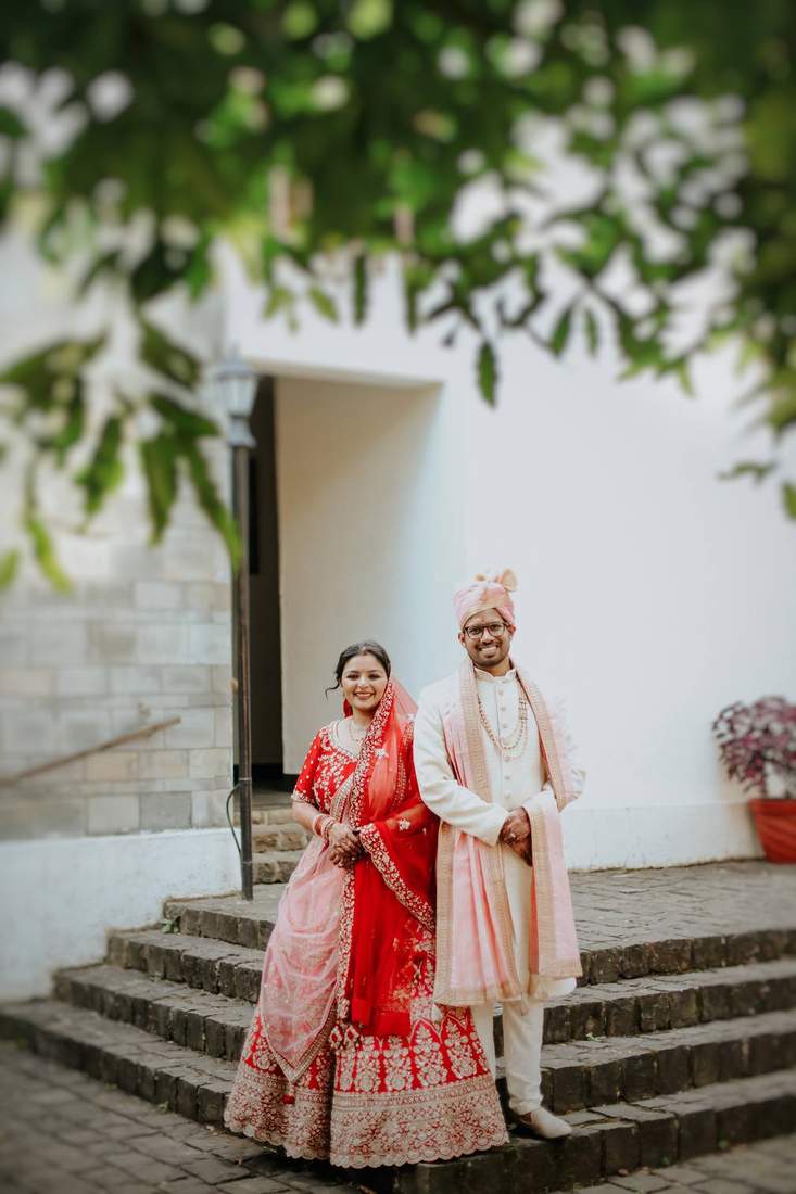 Couple portrait on a stone stairway framed by leaves