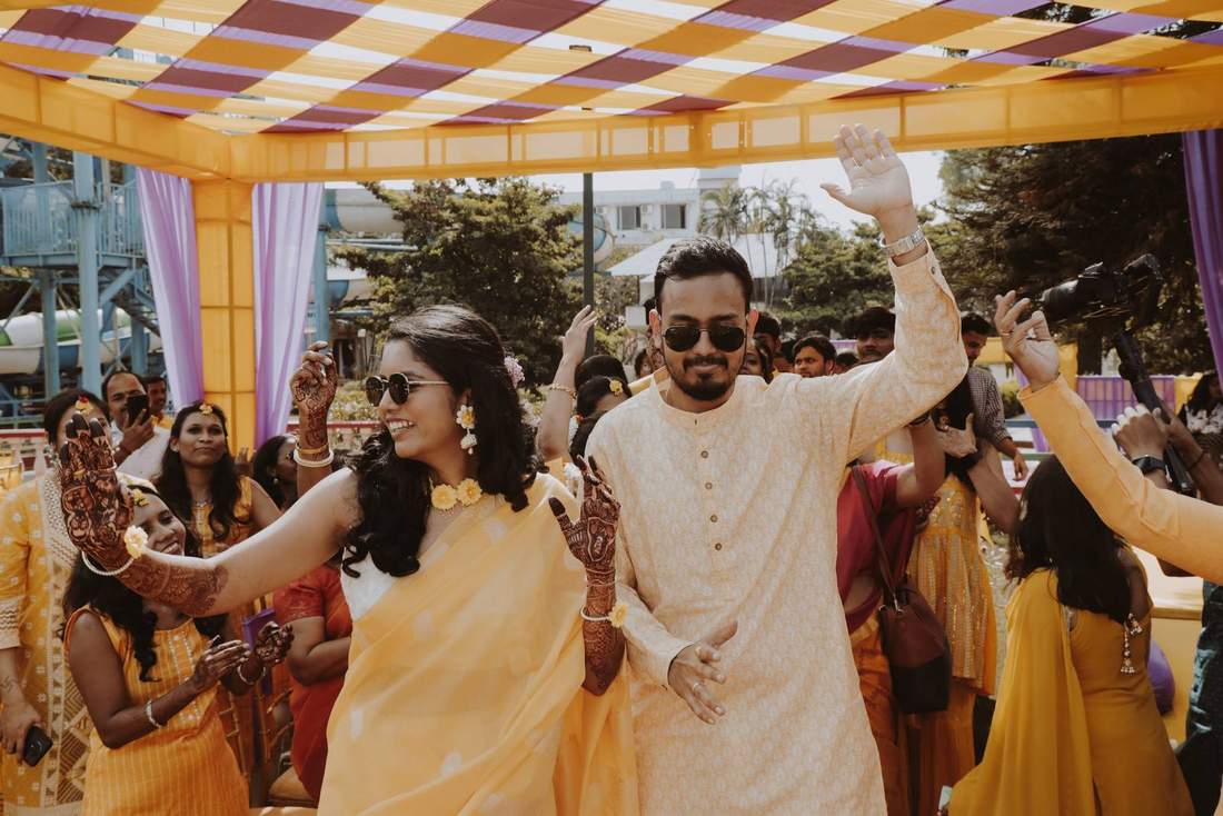 Couple dancing together under a decorated tent during haldi