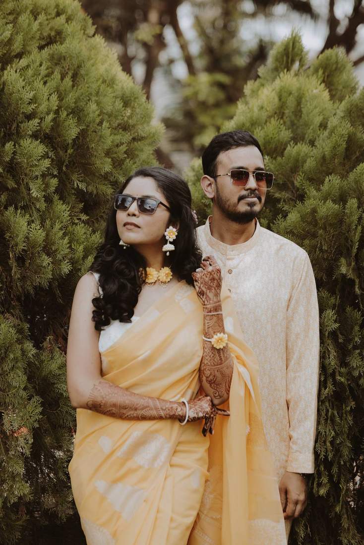 Couple in matching yellow, sunglasses on, looking off into the distance