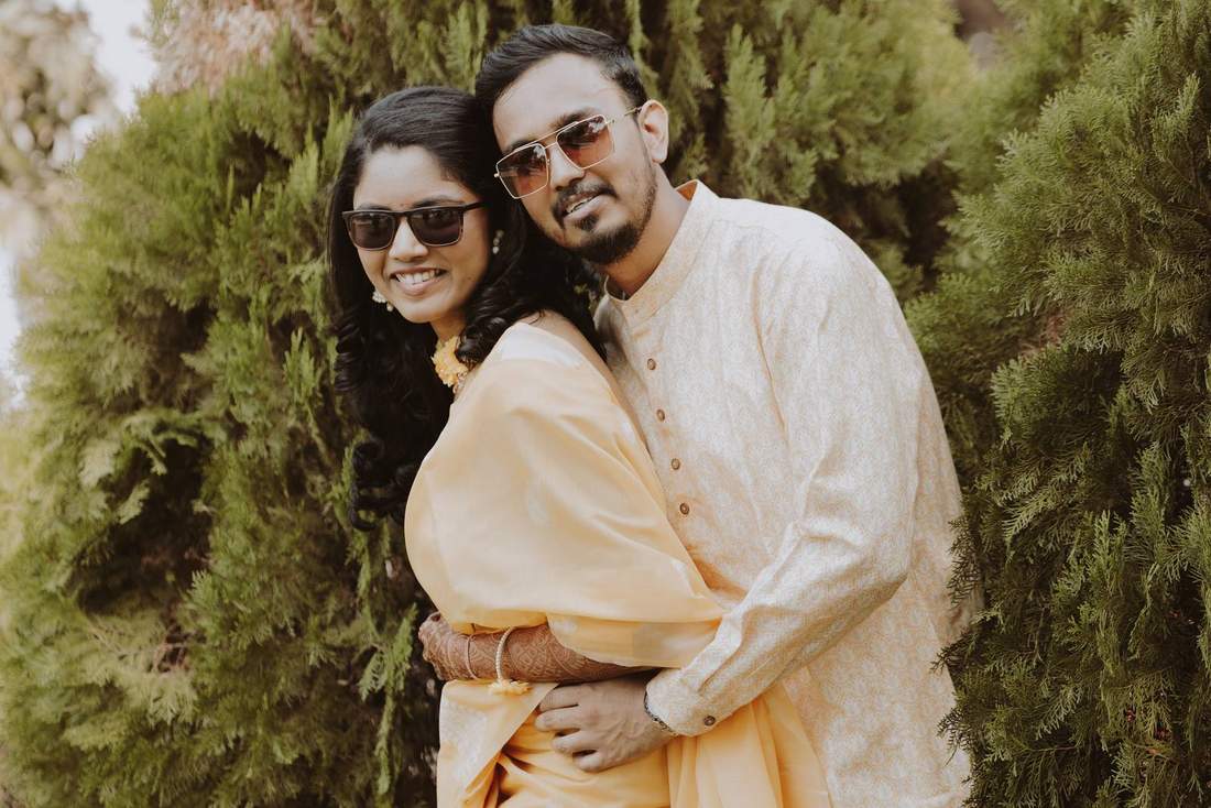 Couple sharing a close embrace, both wearing sunglasses