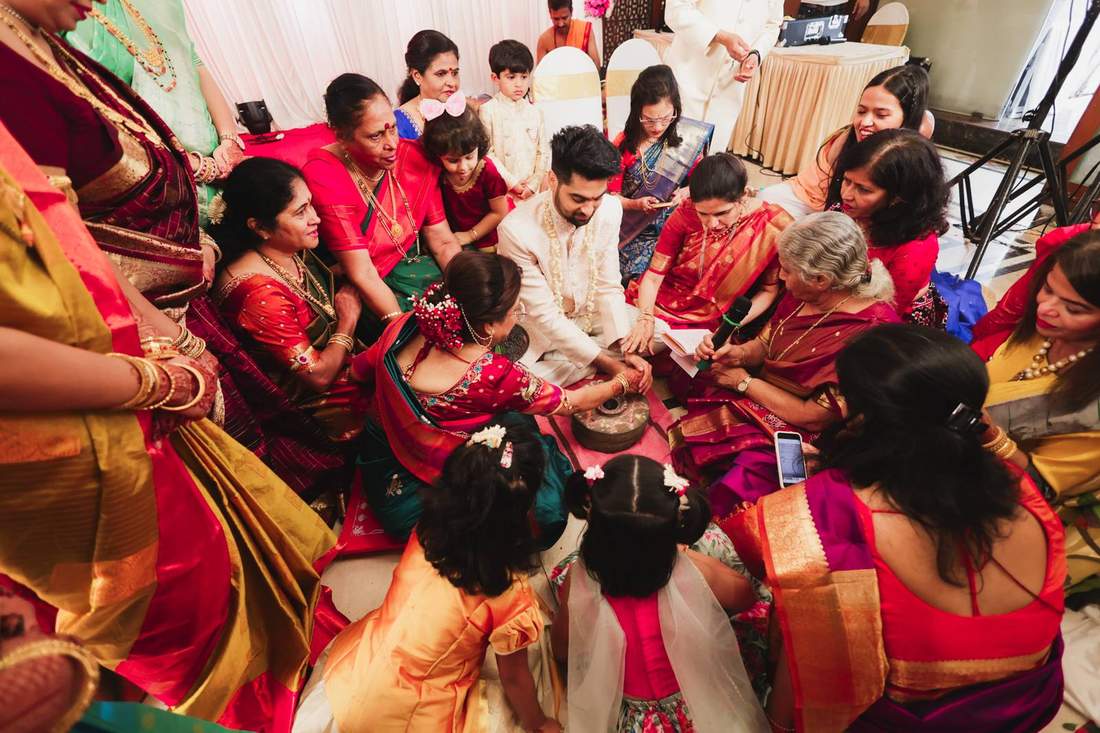 Groom seated with family during a traditional blessing ritual