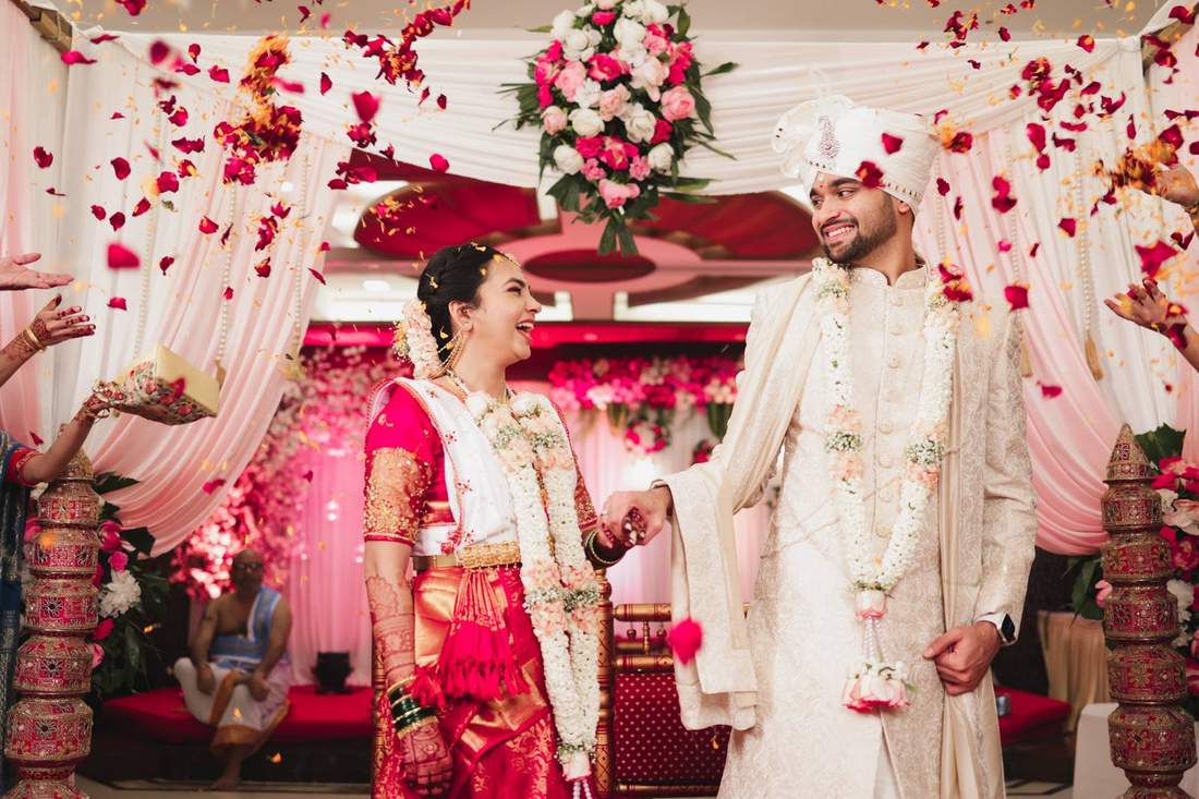 Couple walking hand in hand under a shower of rose petals