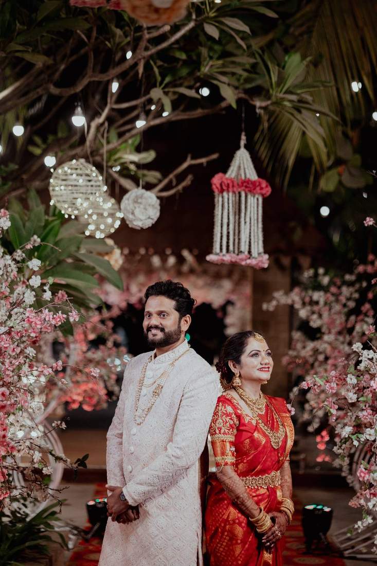 Couple posed back-to-back amid a cherry blossom reception backdrop