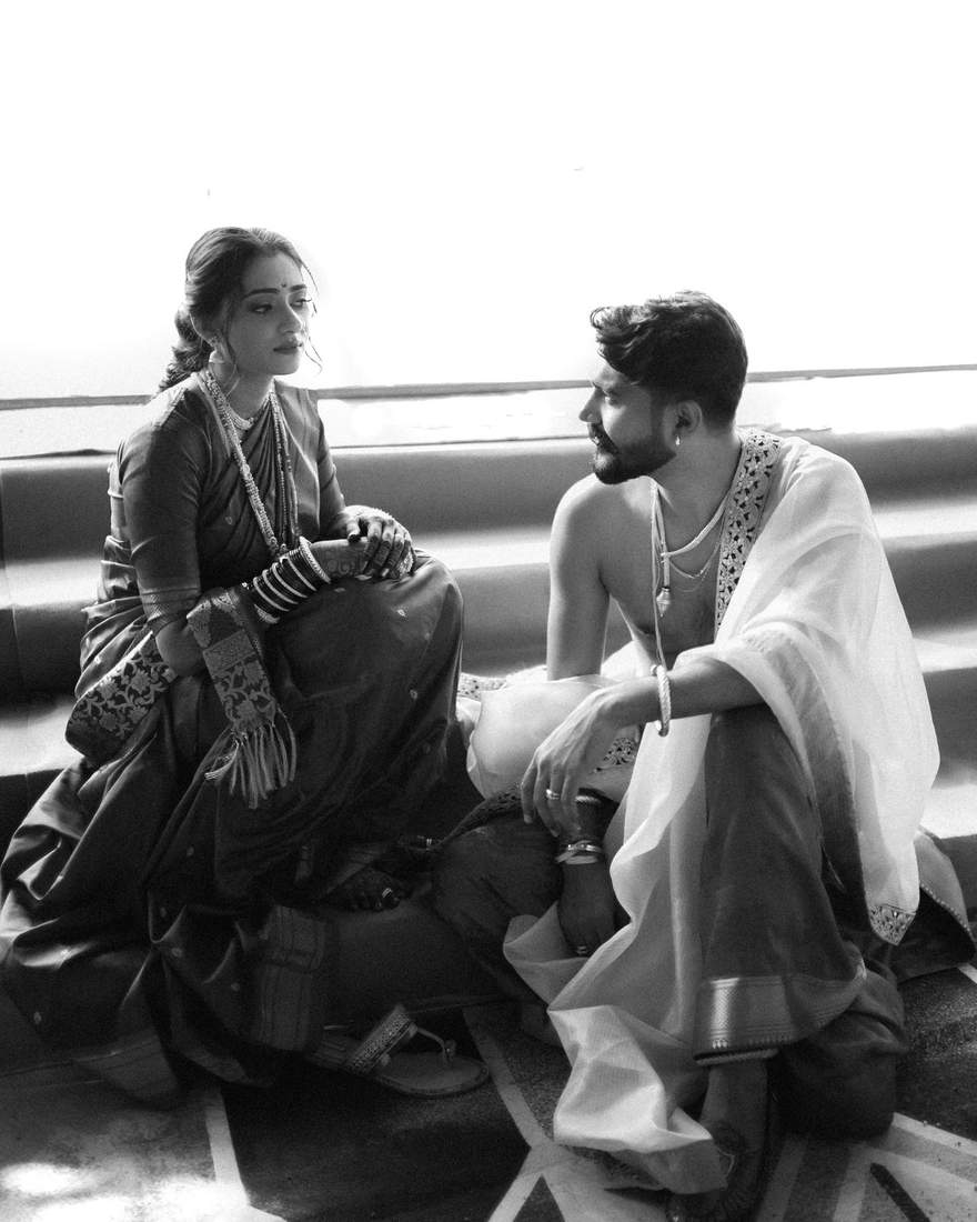 Black and white candid photo of bride and groom sitting and talking quietly