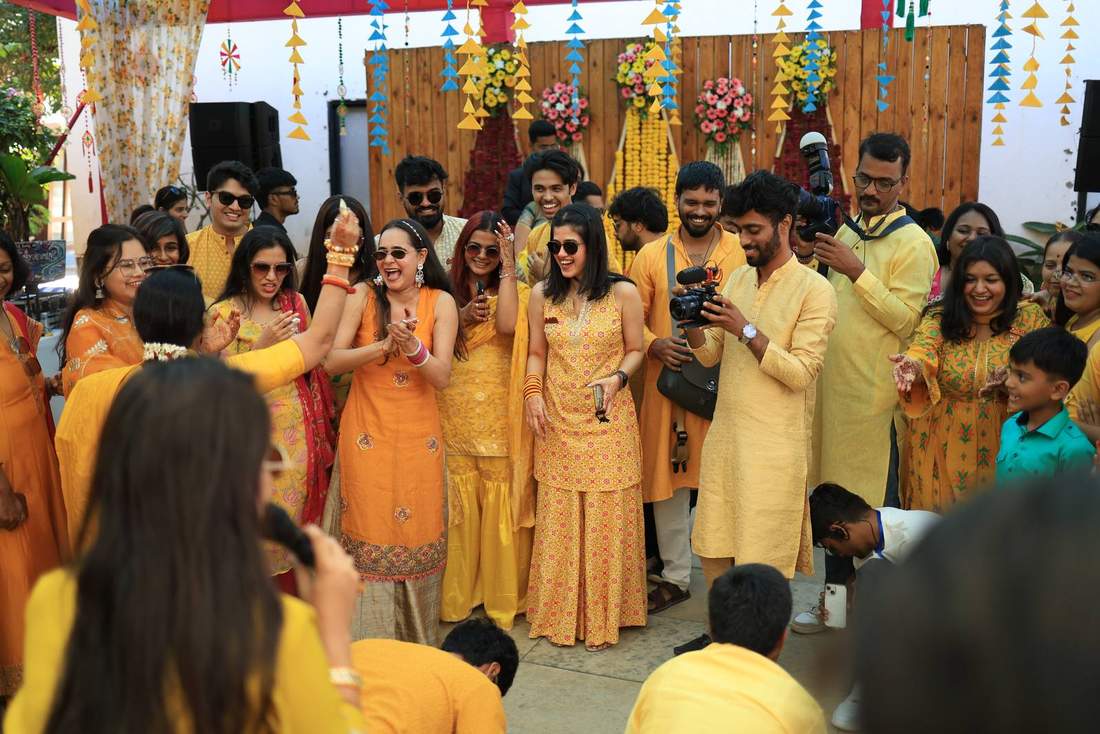 Large wedding party cheering together under a floral backdrop