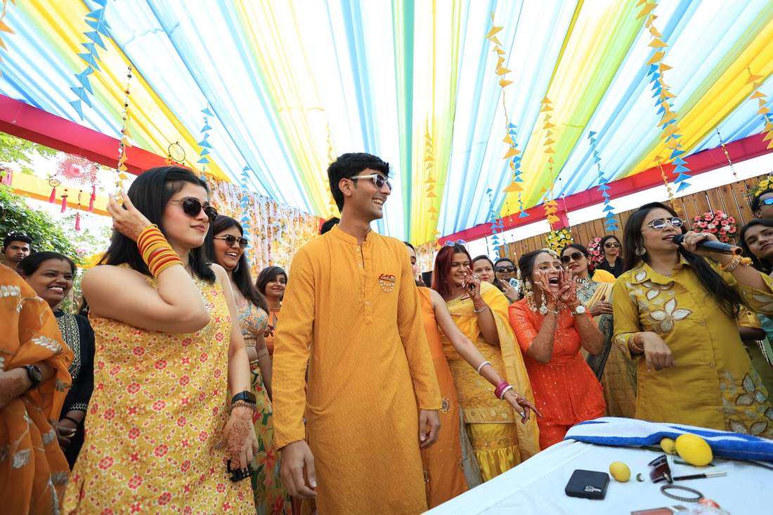 Wedding party singing and dancing together under a colourful tent