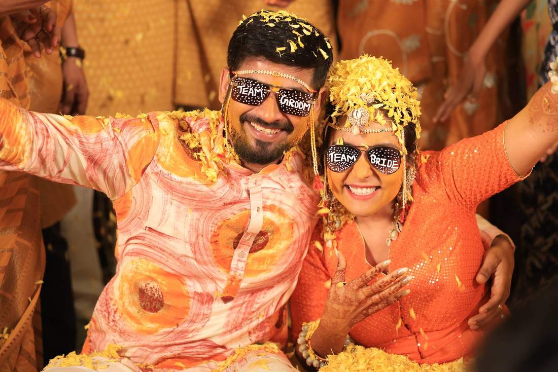 Bride and groom wearing custom Team Bride and Team Groom sunglasses, covered in petals