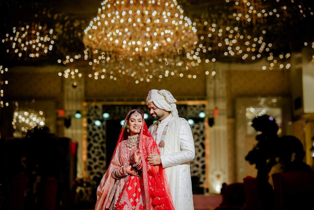 Couple portrait against a bokeh chandelier background