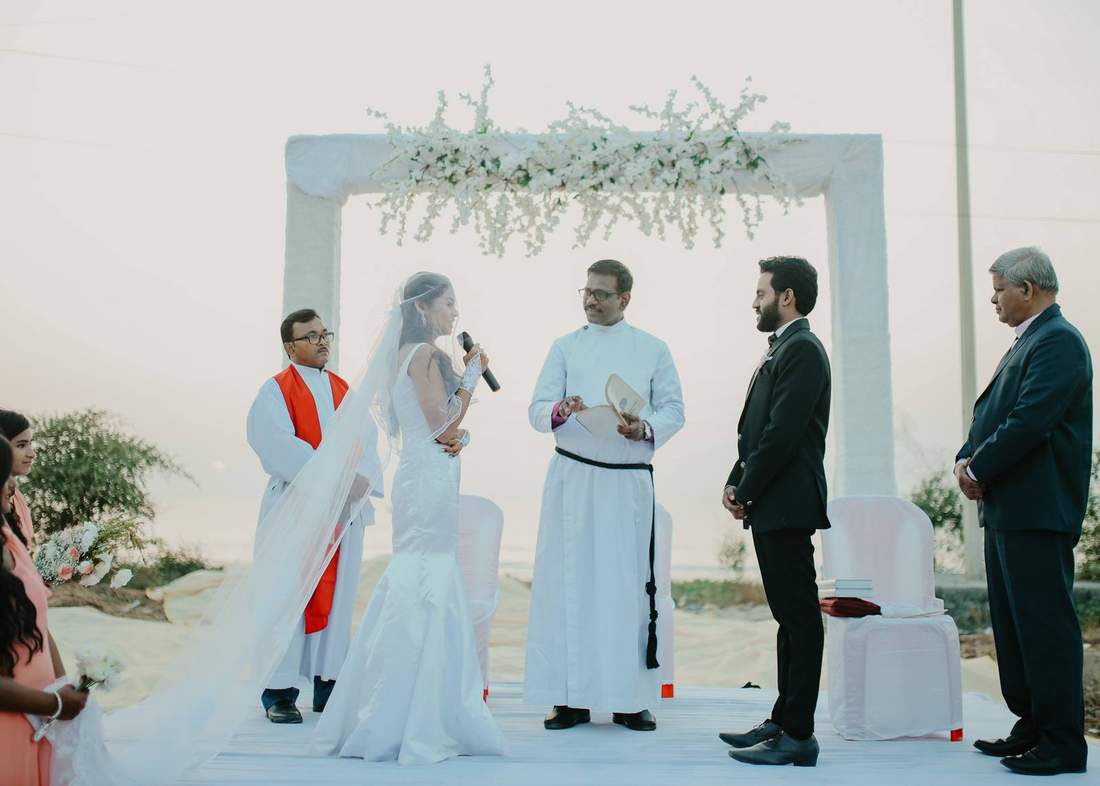 Bride and groom exchanging vows at a beachside ceremony